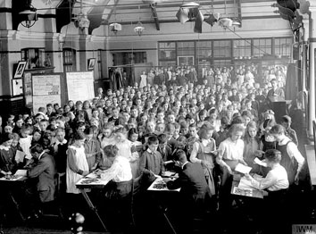 1916: des écoliers londoniens paient leur contribution hebdomadaire à la "War Savings Association". (©IWM)