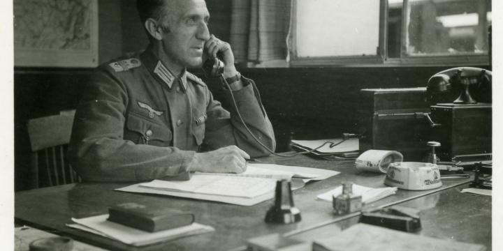 Un officier allemand dans un bureau belge à la gare de Mons. La Wehrmacht Verkehrs Direktion prend en charge de manière agressive des pans entiers de la gestion stratégique et opérationnelle de la SNCB. Source : collection privée Paul Pastiels.