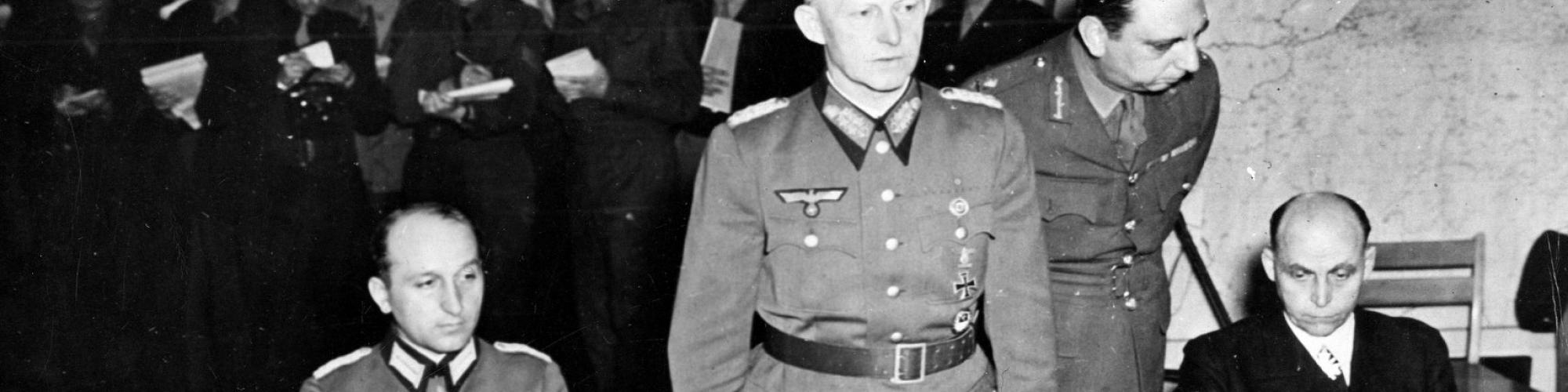 Victory in Europe, Reims 7/5/1945. Colonel General Gustav Jodl, Nazi Chief of Staff, stands at the table in the war room of Supreme Headquarters Allied Expeditionary Force at Rheims, France, ready to sign unconditional surrender terms of the Allied Governments. Seated at left is Major General Wilhelm Oxenius, aide to General Jodl; seated at right is General Admiral Hans Georg von Friedeburg. U.S. Signal Corps Photo ETQ-HQ-45-45298. Serviced by London OW1 to list B. Certified as passed by Shaef Censor. [Belg